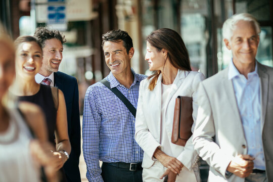 Group of professional colleagues laughing and walking together in the city