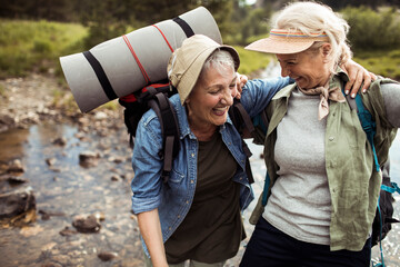 Two senior women walking in the forest