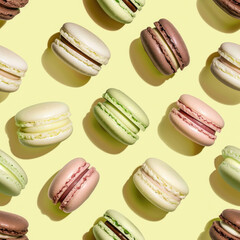 Pattern with macaroons in pastel colors on yellow backdrop