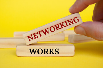Obraz premium Hand placing wooden block on yellow cover with text - Networking works