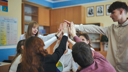 High school seniors join hands in class as a sign of working together. - Powered by Adobe