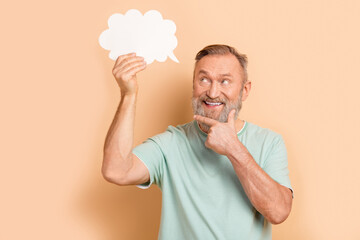 Photo of minded intelligent pensioner wearing trendy clothes solving question looking up empty space isolated on beige color background