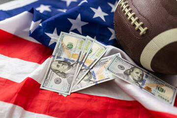 Money and rugby ball on american flag background, closeup. Concept of sports bet