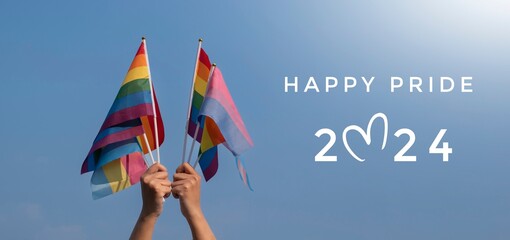 Happy Pride 2024 on rainbow flags raising background, concept for celebrations of LGBTQAI people in pride month, June, around the world.