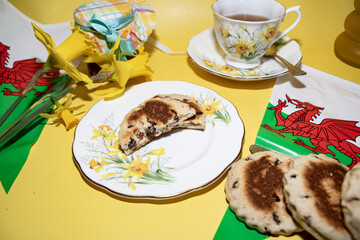St davids  day  celebrations welsh  Flags  Welsh cake  Daffodils   Vintage  tea  party  and  teacup  on a yellow  back ground 