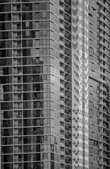 Fototapeta premium Corner View of a Building with Window Reflections in Black and White.