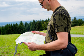 Man with touristic map in hands. Traveling Using Map. Man Holding Map In Hands. Looking For...