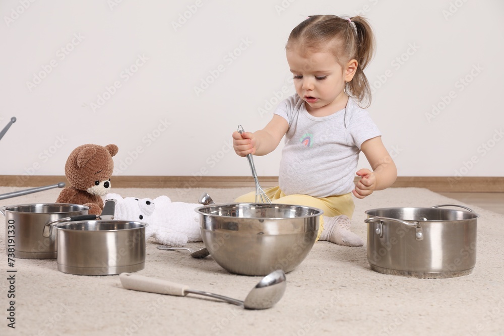 Wall mural Cute little girl with cookware at home