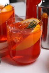 Aperol spritz cocktail, rosemary and orange slices on white wooden table, closeup