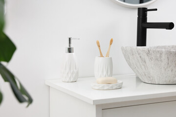 Different bath accessories and personal care products on bathroom vanity indoors