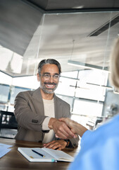 Happy mature business man recruiter hr manager and new employee handshake at job interview. Smiling...