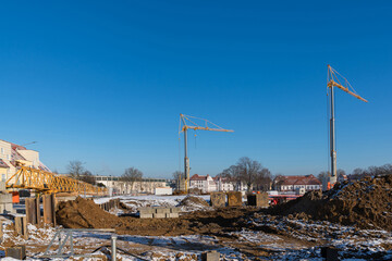 Fototapeta na wymiar Construction site during the start of excavation work. Construction cranes in the background.