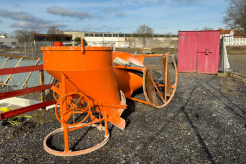 Orange colored mechanisms for mixing building components on a construction site.