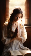 Praying woman in white dress near window - obrazy, fototapety, plakaty