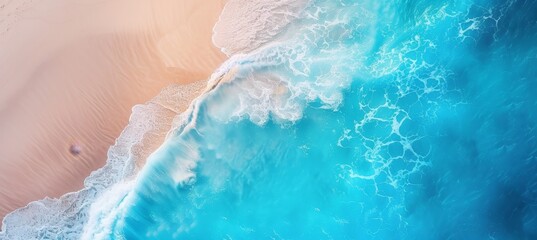 Fototapeta na wymiar Aerial view of coastal seascape with blue ocean waves, white foam, and yellow sand beach from above.