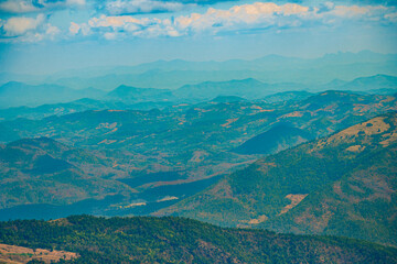 Fototapeta premium The stunning view in Forest Park from a tourist's standpoint as they go down a hill with background of blue sky, Rainforest, Thailand. Bird's eye view. Aerial view. 