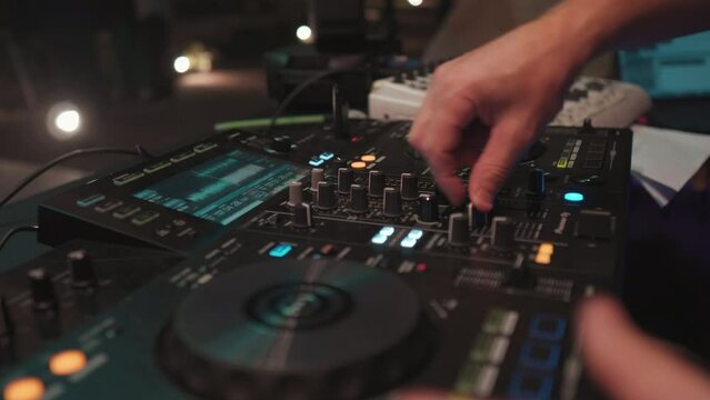 La mano del hombre en la mesa de mezclas de música de DJ. Scratching Imagen en cámara lenta