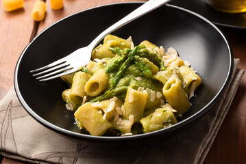 Piatto di deliziosa pasta con crema di asparagi selvatici e pecorino, cibo italiano 