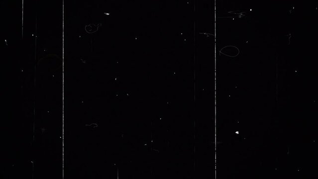 Overlay of black background with screen with scratches and white dots from dust