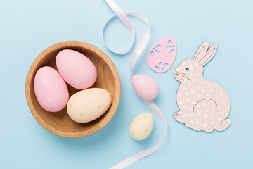 Easter bunny with eggs on color background, top view