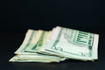 A pile of money including five dollar bills and twenty dollar bills.