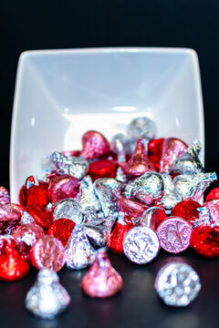 A white square bowl tipped over spilling candy.