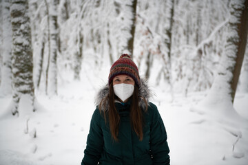 Fototapeta na wymiar Woman in Winter Attire Standing in a Snowy Forest