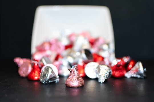 A white square bowl tipped over spilling candy.