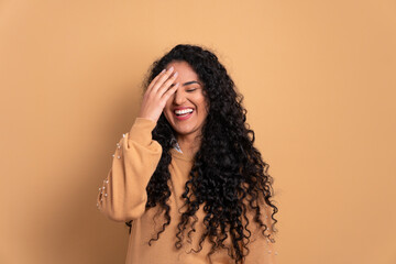 fun afro brazilian woman laughing happily in studio shot. portrait, real people concept.