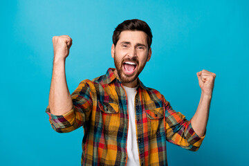 Photo portrait of handsome young male raise fists win yell yeah dressed stylish checkered outfit...