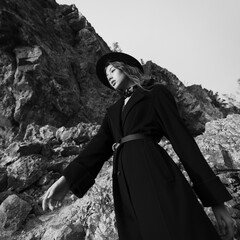 Fashion portrait of a girl dressed in a black coat and hat. - 738246153