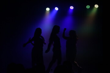 People dancing in the dark with nightclub lights