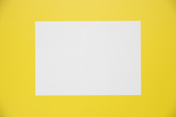 Empty white paper sheet isolated on yellow background