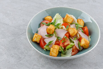salad with ham and halloumi cheese on a stone background studio food photo 1