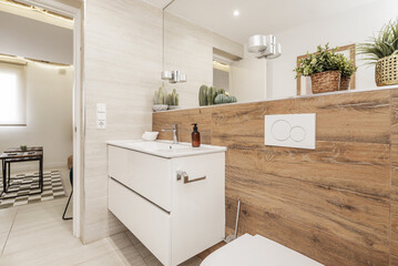 A bathroom with wood-like stoneware tiles, white wooden furniture, endless mirror integrated into the wall, white porcelain sink and stoneware floor - obrazy, fototapety, plakaty