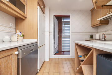 a kitchen with stripped wood furniture, various appliances and access to a laundry terrace