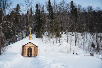 a small wooden church in the middle of a snowy forest