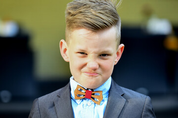 Fashion kid boy in suit and bow tie. Lifestyle portrait of funny kid outdoors. Summer kids outdoor...