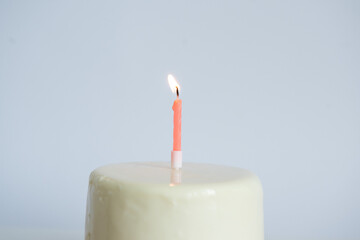 White mini birthday cake with one candle.