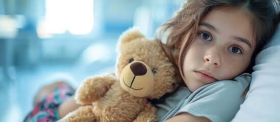 Young girl occupying herself with a teddy bear while anticipating a medical procedure at the hospital.