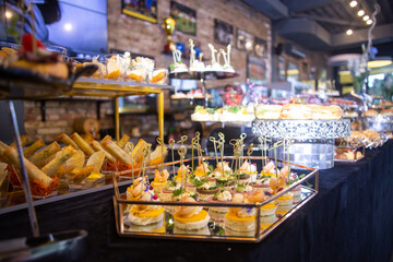 buffet table with a black tablecloth with various snacks and treats catering