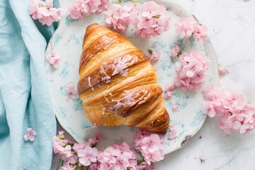 plate of freshly baked croissant decorated with beautiful flowers.international croissant day