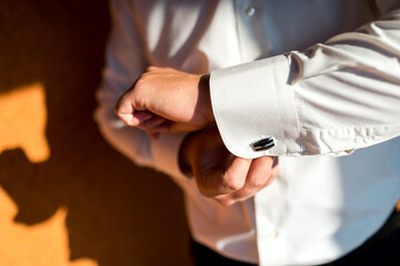 Man wears shirt cufflinks,groom getting ready in the morning before wedding ceremony