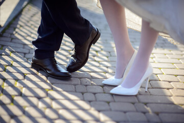 The bride and groom stand on the pavement
