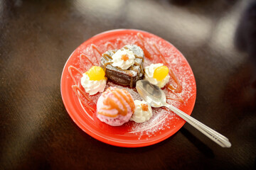 Plate of dessert with spoon on wooden table