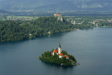 tiny island with church tower and nature in the middle of gorgeous clear water blue lake