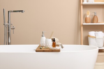 Different personal care products and accessories on bath tub in bathroom
