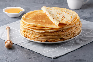Stack of traditional russian pancakes blini on gray background with copy space. Homemade russian thin pancakes blini. Russian food, russian kitchen