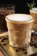 Refreshing iced coffee with milk in glass on table, closeup