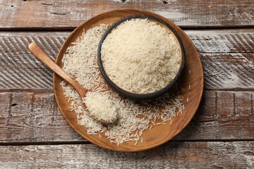 Raw basmati rice on wooden table, top view